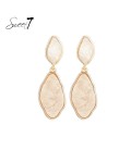 Beige oorhangers met een goudkleurige rand