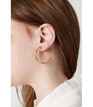 Goudkleurige oorclips met een gedraaide ring en een kunststof clipje