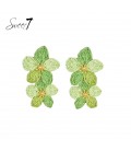 Oorbellen met twee bloemen in groene tinten van Raffia