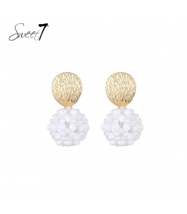 Oorbellen met goudkleurige schijf en witte kralenbol.