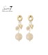 Oorbellen goudkleurig met een harten bedel en een beige kraal