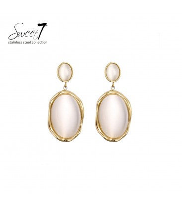 Beige oorbellen met een goudkleurige rand en een cat eye steen